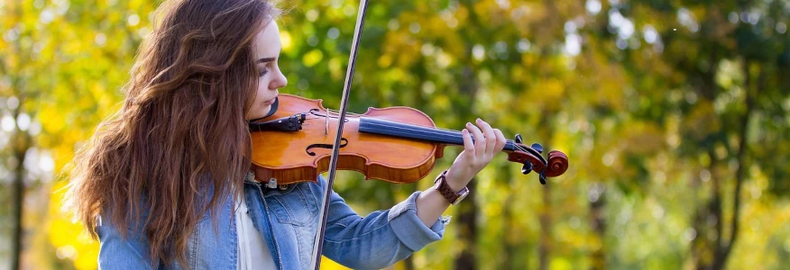 jeune fille joue du violon dans un parc